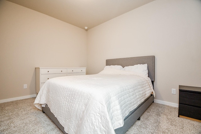 bedroom with lofted ceiling and light colored carpet