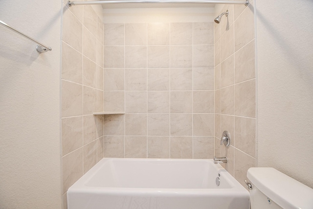 bathroom featuring tiled shower / bath combo and toilet