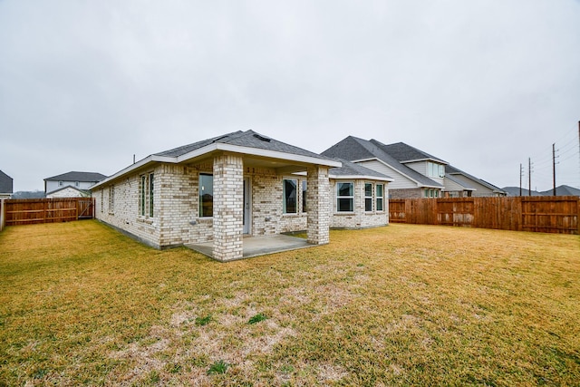 rear view of house with a patio area and a lawn