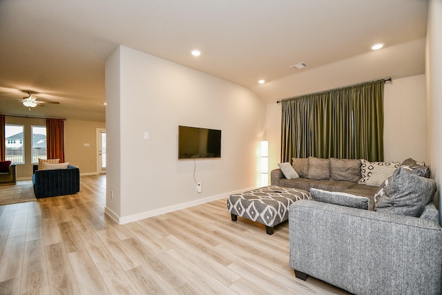 living room featuring ceiling fan, lofted ceiling, and light wood-type flooring