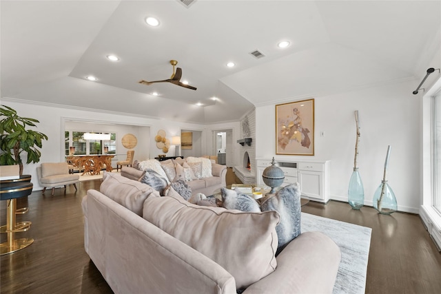 living room with a raised ceiling, ornamental molding, and dark wood-type flooring