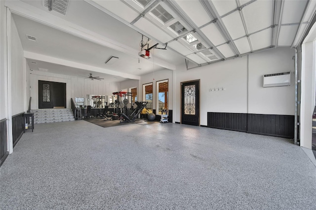 garage with a garage door opener, an AC wall unit, and ceiling fan