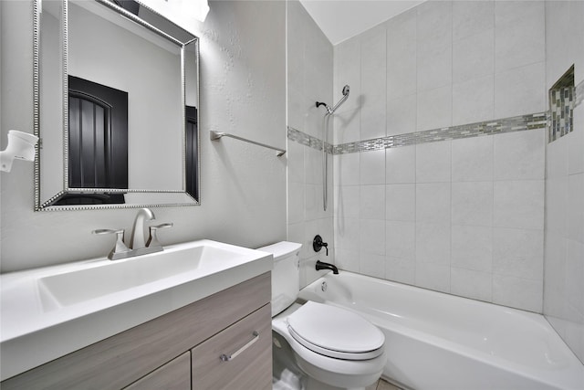 full bathroom with vanity, tiled shower / bath, and toilet