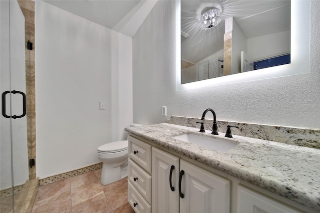 bathroom with a shower with door, vanity, and toilet