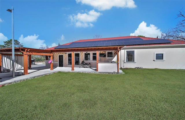 back of property with a lawn, a pergola, a patio area, and solar panels