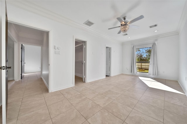 unfurnished bedroom featuring light tile patterned flooring, a spacious closet, ornamental molding, a closet, and ceiling fan