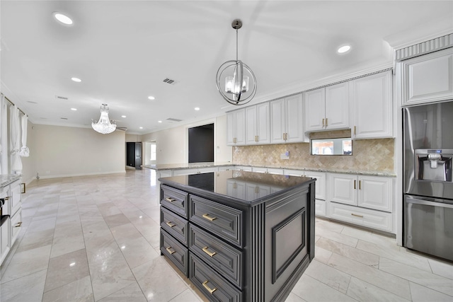 kitchen with pendant lighting, stainless steel fridge, a center island, and decorative backsplash