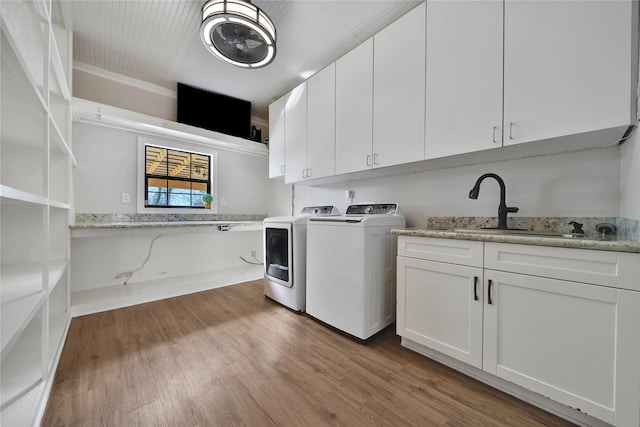 washroom with cabinets, sink, washer and clothes dryer, and light hardwood / wood-style floors