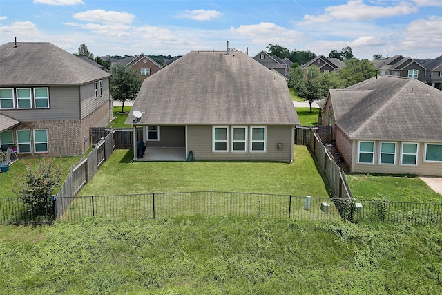 rear view of house with a yard and a patio area