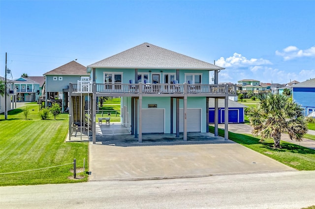 beach home featuring a balcony and a front lawn