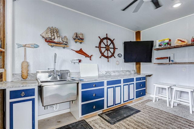 kitchen with blue cabinets, sink, and ceiling fan