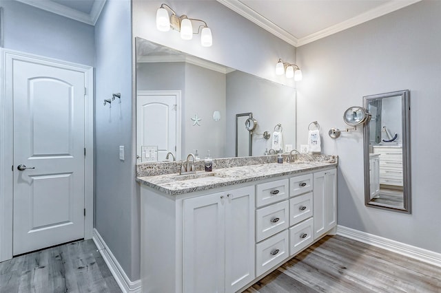 bathroom featuring hardwood / wood-style flooring, ornamental molding, and vanity