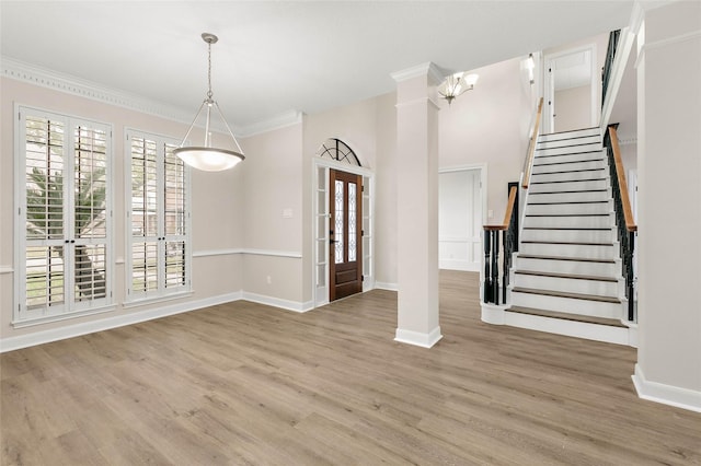 entrance foyer featuring hardwood / wood-style flooring, ornamental molding, and a healthy amount of sunlight