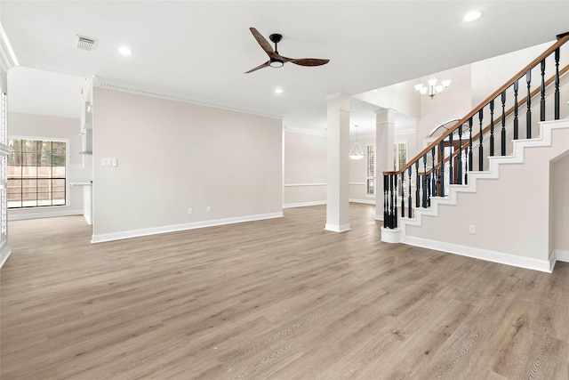 unfurnished living room featuring crown molding, ceiling fan with notable chandelier, light hardwood / wood-style flooring, and ornate columns