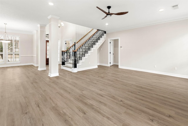 unfurnished living room featuring hardwood / wood-style flooring, crown molding, and ceiling fan with notable chandelier