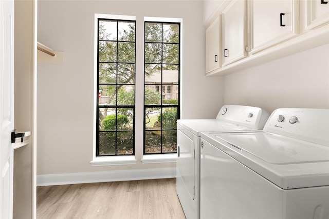 laundry room with independent washer and dryer, cabinets, and light hardwood / wood-style floors