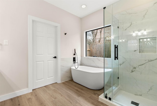 bathroom with separate shower and tub, hardwood / wood-style floors, and tile walls