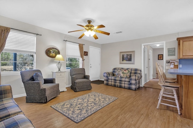 living room with light hardwood / wood-style flooring and ceiling fan