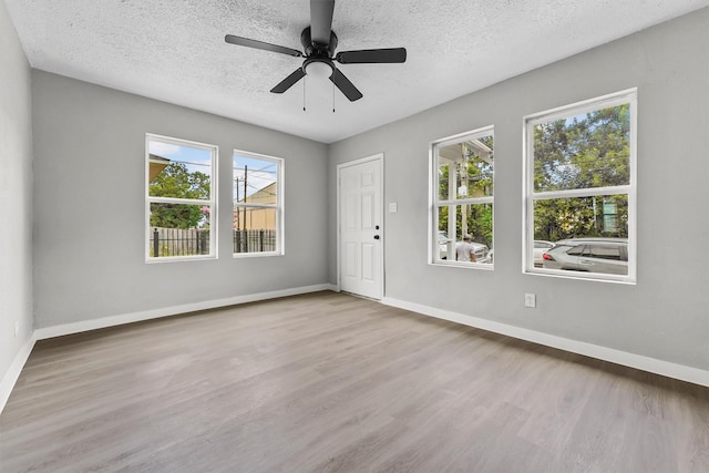 unfurnished room featuring ceiling fan, a textured ceiling, and light wood-type flooring