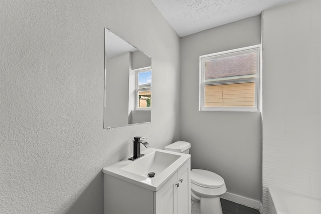 bathroom featuring vanity, toilet, and a textured ceiling