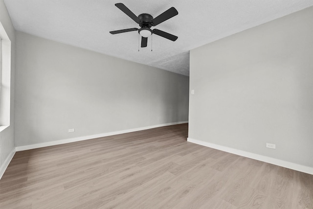 spare room with ceiling fan, light hardwood / wood-style flooring, and a textured ceiling