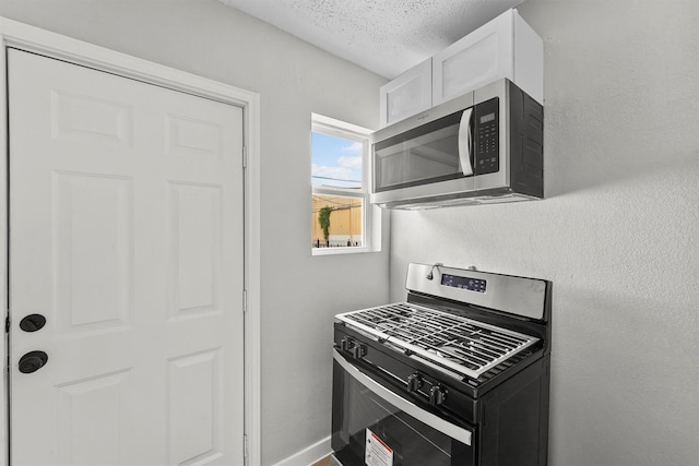 kitchen featuring white cabinetry, appliances with stainless steel finishes, and a textured ceiling