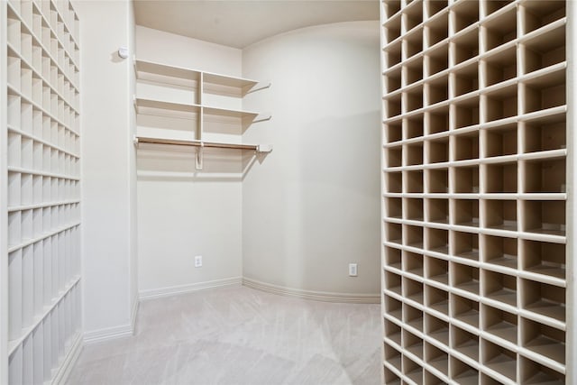 walk in closet featuring light colored carpet