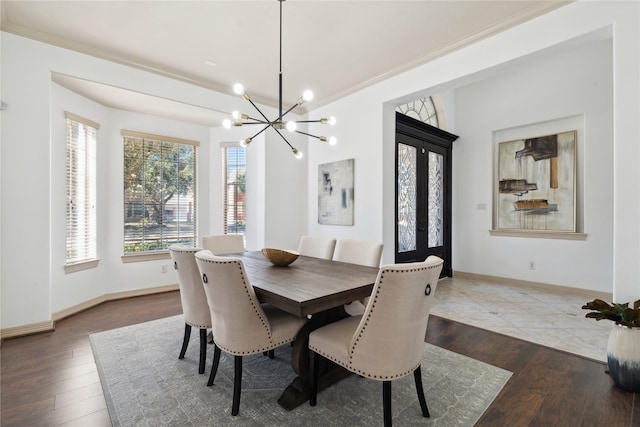 dining area featuring french doors, crown molding, a chandelier, and hardwood / wood-style floors