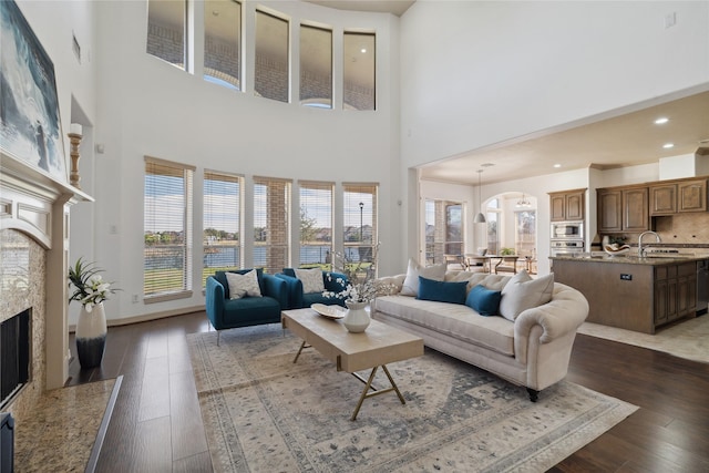 living room with a high end fireplace, dark hardwood / wood-style floors, and sink