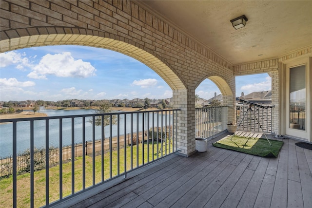 deck with a water view and a lawn