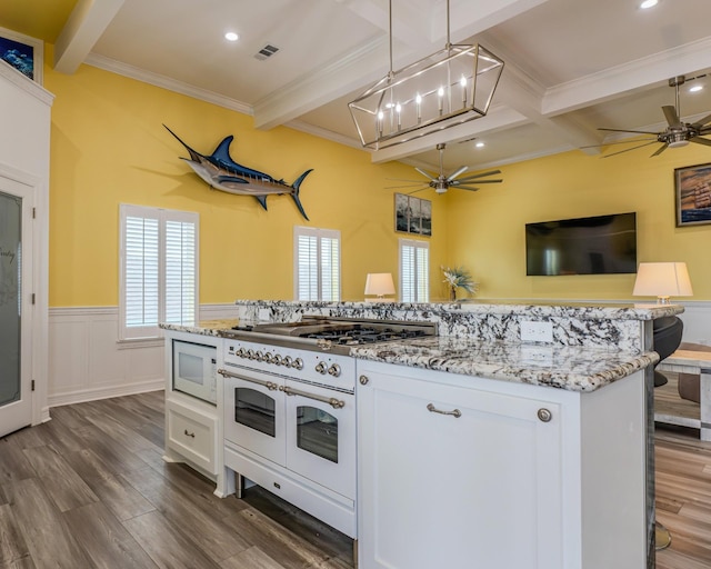 kitchen featuring white appliances, hanging light fixtures, beam ceiling, light stone counters, and white cabinets