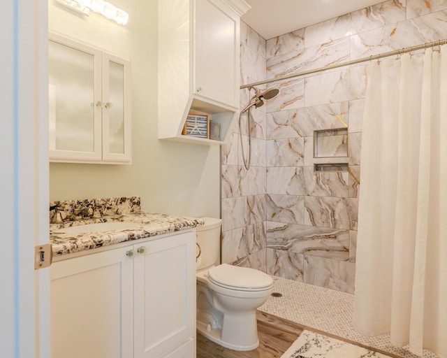 bathroom with vanity, toilet, curtained shower, and hardwood / wood-style floors