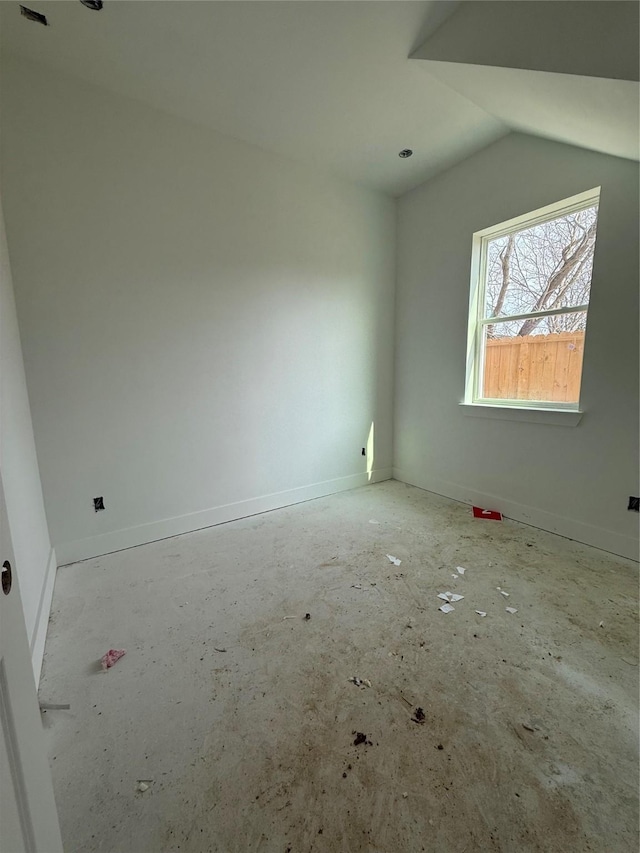 unfurnished room with vaulted ceiling