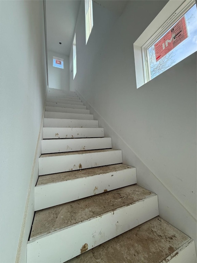 staircase featuring a towering ceiling