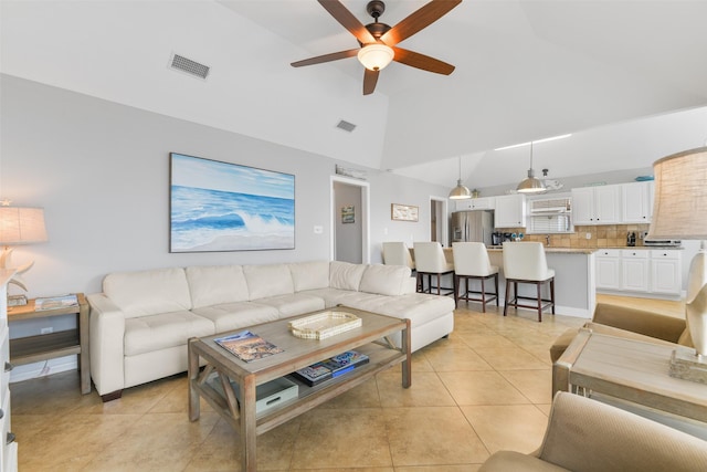 tiled living room featuring high vaulted ceiling and ceiling fan