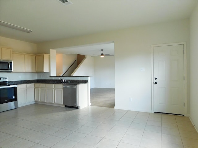 kitchen with light tile patterned flooring, ceiling fan, appliances with stainless steel finishes, and sink