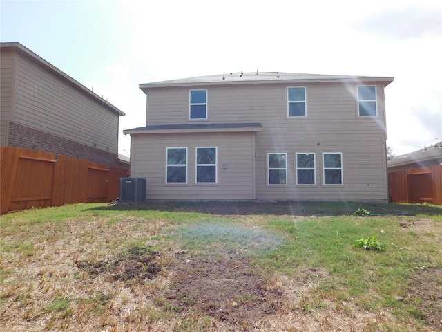 back of house with cooling unit and a lawn