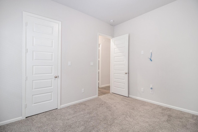 unfurnished bedroom featuring light carpet