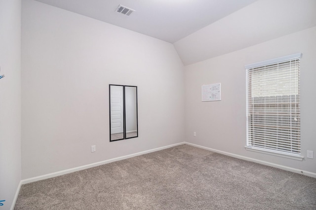 empty room featuring vaulted ceiling and carpet floors