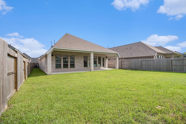 back of property with a yard and a patio area