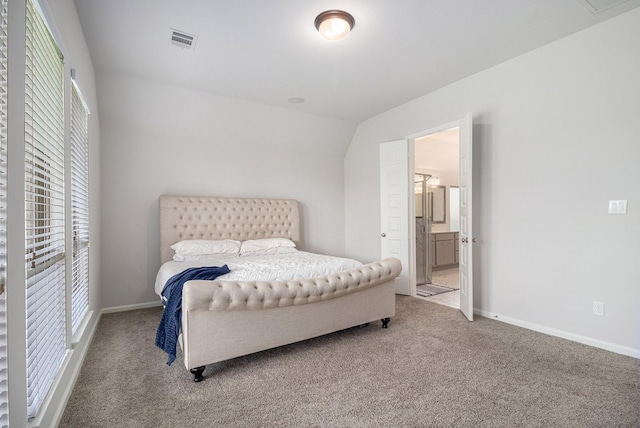 carpeted bedroom featuring lofted ceiling and ensuite bathroom