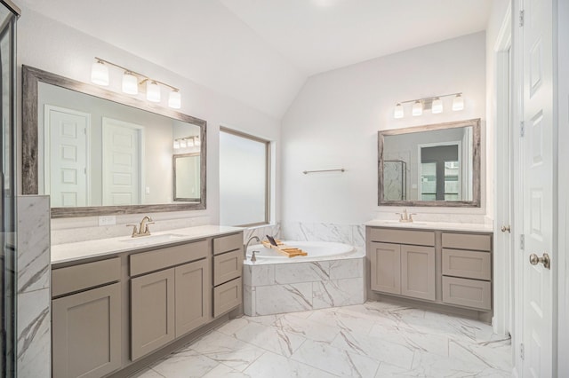 bathroom with vaulted ceiling, tiled bath, and vanity