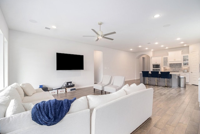 living room with light hardwood / wood-style floors and ceiling fan