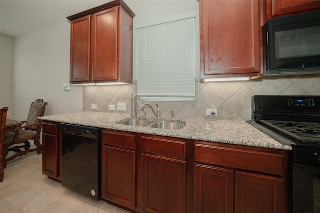 kitchen with light stone counters, sink, and black appliances