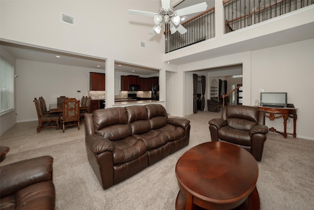 carpeted living room featuring a high ceiling and ceiling fan