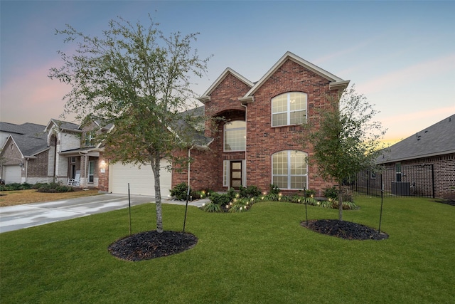 view of property featuring a garage, central AC unit, and a lawn