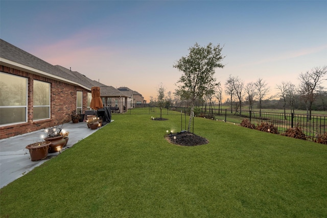 yard at dusk with a patio area