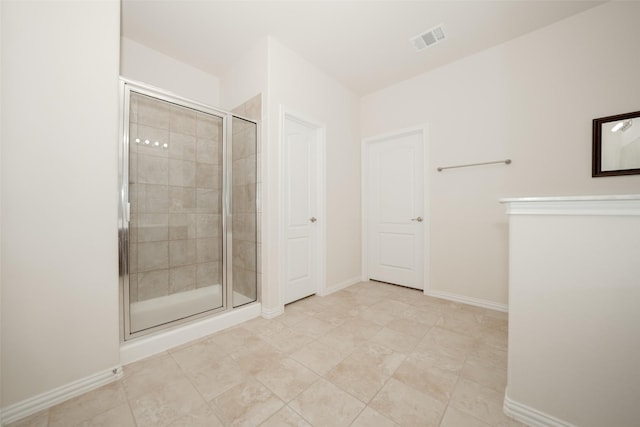 bathroom with tile patterned flooring and a shower with shower door