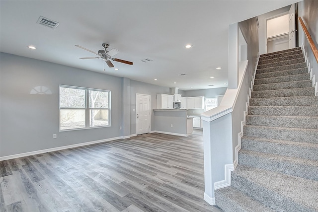 stairs with ceiling fan and wood-type flooring