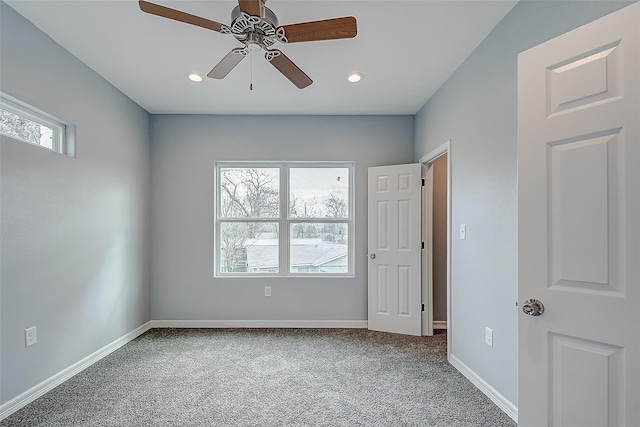 carpeted spare room with ceiling fan